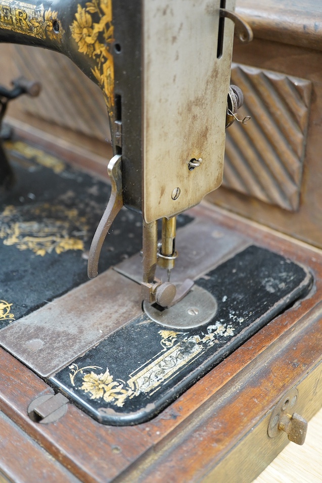 An early 20th century cased Singer sewing machine, 46cm wide at base. Condition - poor